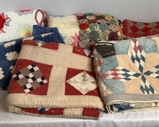 Approximately (8) quilts that appear to be homemade, (1) is crocheted. Includes (1) blue and white crocheted squares, (1) multi-colored gathered circles, (1) is white with pastel colored 6-point stars and more. See pictures for details. Some may have tears, worn areas or staining.