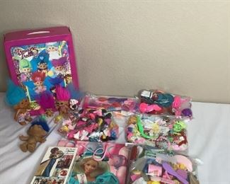 Includes bins with approximately (7) bags of Barbie clothes and accessories, (1) VHS tape of "The World Of Barbie" collection, unopened, (6) Treasure Troll dolls in various sizes with case and more!