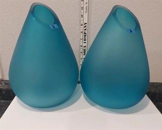 a pair of thick, aquamarine colored glass vases