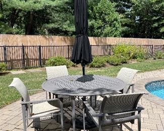 Brown and Jordan cast and extruded aluminum outdoor patio set with four chairs. Umbrella included with base.  57’ round