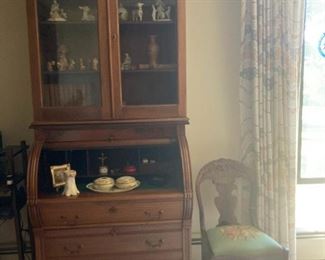 Antique roll top Secretary with glass display cabinet, vintage needlepoint seat chair, Anri wood carved figurines from Italy