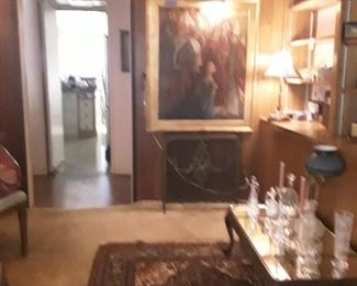 cut glass on mirrored coffee table.  awesome large painting, Victorian fireplace screen underneath.  Persian rug, one of the many