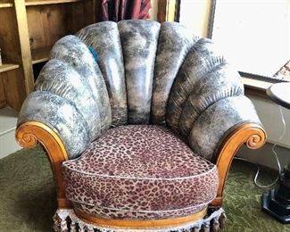 Chairs feature a distressed grey leather scallop back,  animal print seat, roll wood arms  and tassel trim base