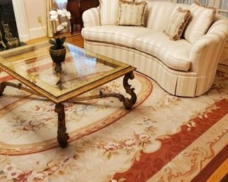 Kidney shape sofa by Stickley. Oversized glass coffee table with carved fruitwood frame. Aubusson roomsize carpet