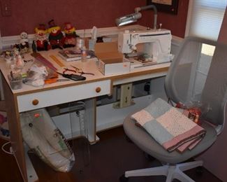 Crafts/Sewing Work Center featuring Husqvarna Viking Mega Quilter with an adjustable Crafts table with many sewing items and a very nice Office Chair