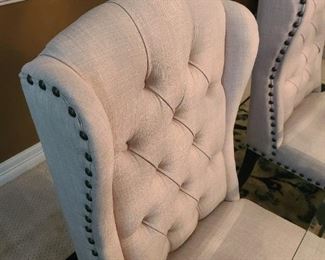 Light grey tufted wingback with nail head trim