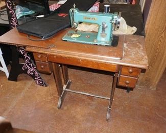 sewing machine in wood treadle cabinet