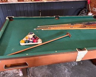 pool table with balls and cues