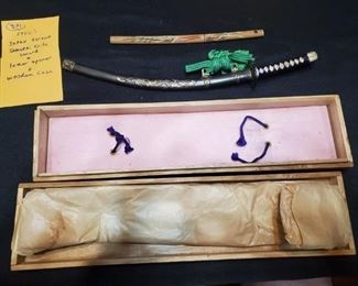 Miniature Katana / samurai swords brought back from overseas by a US soldier in the 1950s .  The metal sword has Dragons on it and has its wooden case.  The smaller sword is probably a letter opener. 
