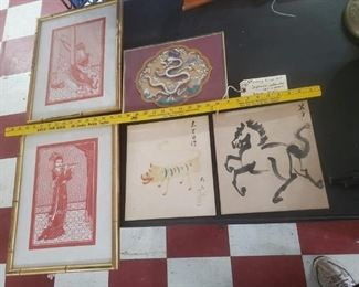 5 pieces of Asian art.  The 2 musician prints at left are framed under glass and have faux bamboo wooden frames, flute player and harp player.  The 2 at bottom right are watercolor paintings, appear to be Japanese.  The yellow critter is a Haruko Tiger, don't know about the horse.  We think the dragon is acrylic on cardboard, not positive but he is creepy. 