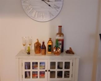 Whitewashed wooden cabinet. 
Collection of unusual liquor bottles 