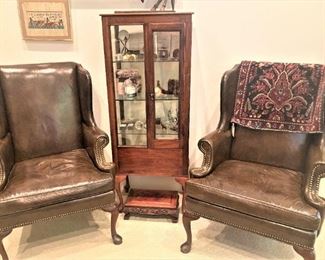 Matching brown leather wingback chairs; display cabinet