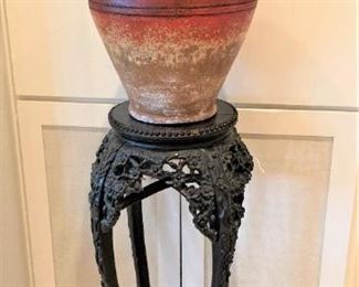 One of two matching carved plant stands and vases