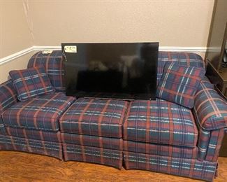 Plaid sleeper sofa & flat screen tv.