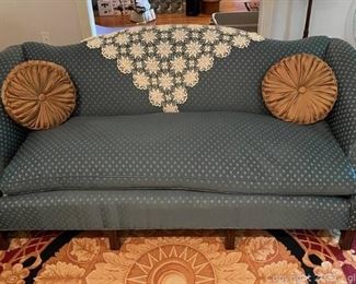 Blue Camelback Sofa with Accent Pillows and Doily