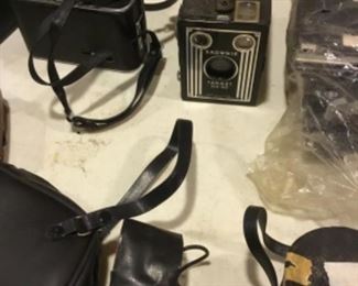 Downstairs- Table full of vintage cameras, binoculars, and movie cameras