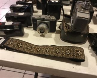 Downstairs- Table full of vintage cameras, binoculars, and movie cameras