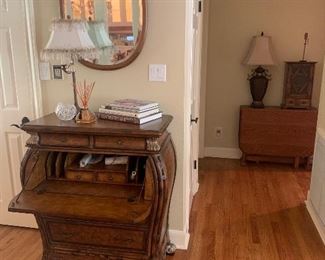 Bombe-style entryway piece made in Indonesia with  drop-down secretary, antique carved golden oak oval mirror.