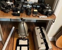 Lots of camera equipment from a former P.I. There's even a tiny spy camera in there, a tripod, and an antique daguerrotype camera, foam lined cases, flash, lenses, attachments, etc.