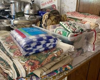 Lots of kitchen linens - towels, pot holders, tablecloths, etc