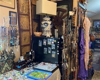 We are still researching these two beautiful antique framed wall pictures in this photo and are hoping to include them in the sale.  Jewelry everywhere 😊.  Entire table full of brooches, sterling silver jewelry including Indian jewelry and two racks full of necklaces.  Additional necklaces are located in flats and on another rounder not pictured here 