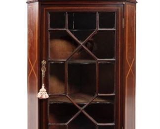 3217
A Chippendale-Style Hanging Corner Cabinet
First-Quarter 20th Century
The mahogany corner cabinet with a swan neck pediment centering a eagle finial over a dentil molding and decorated with inlaid strapwork, with a single glazed door revealing three serpentine shelves
46" H x 26.75" W x 18" D
Estimate: $600 - $800
