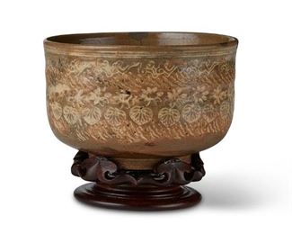 3258
A Japanese Yatsushiro Ware Ceramic Teabowl
Mid-18th Century, Edo Period (1603-1868)
The base numbered: R.5771.47-34; with paper label: Mishima Yatsushiro Teabowl / Date 1750
The celadon and cream teabowl (chawan) of the mishima type, with bands of carved calendrical marks, inlaid cloud, blossom, and leaf designs, with a carved wood stand
Bowl: 3.25" H x 5.25" Dia.; on stand: 4.625" H
Estimate: $1,000 - $2,000