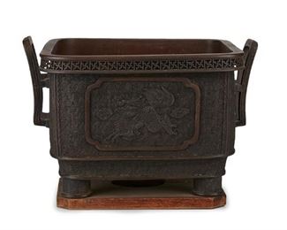 3259
A Japanese Bronze Jardinière
Meiji Period (1868-1912)
The square-form bronze vessel with bas-relief medallions of dragons against a geometric patterned ground flanked by curved handles and raised on cylindrical feet, mounted to a wood base
11.25" H x 16.5" W x 14.125" D
Estimate: $1,000 - $1,500