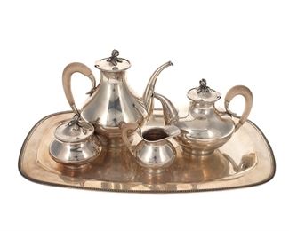 3307
A Spritzer & Fuhrmann Sterling Silver Tea And Coffee Service
20th Century
Each marked: S&F / 925-100 / sterling / [rearing lion]; Variously numbered
Each with dashed trimming, flower bud finials, and wood handles, comprising a coffee pot (7.875" H x 8.125" W x 5.25" D), a teapot (6" H x 7.875" W x 5" D), a covered sugar bowl (4.125" H x 3.75" W x 3.75" D), a creamer (3.5" H x 4.5" W x 3" D), and a serving tray (1" H x 19" W x 12" D), 5 pieces
89.795 gross oz. troy approximately
Estimate: $1,500 - $2,500