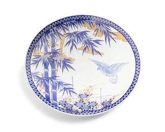 3317
A Large Japanese Arita Porcelain Charger, By Aoki Kyodai-Shokai
Late 19th/Mid-20th Century
With blue underglaze mark for Aoki Kyodai-Shokai [Aoki Brothers Company] to underside
The blue and white glazed porcelain Artia/Imari sometsuke charger decorated with blue underglaze flying bird, bamboo, and flowers and finished with overglaze gilt highlights and enamel details surrounded by a geometric rim and with floral sprays to the verso
3.75" H x 23.75" Dia.
Estimate: $1,000 - $2,000