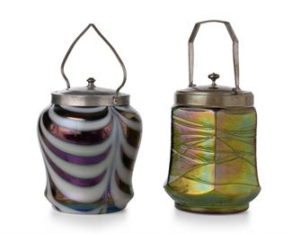 3361
Two Loetz-Style Art Glass Biscuit Barrels
Late 19th/Early 20th Century
The second silver plate marked: Mang [illegible] / Electro Plate
Comprising an iridescent purple jar with white festoons fitted with a hammered metal lid and handle (10"H x 5.25" Dia.) and an iridescent green jar with flared body, and spun threads fitted with a silver-plated lid and handle (10" H x 4.75" Dia.), 2 pieces
Estimate: $400 - $600