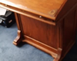 Antique desk with close top and drawers on left side.