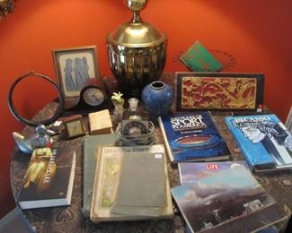 Nice & convenient multi-use particle board table that easily breaks down when not in use. Vintage Stiffel solid brass lamp, Vintage Gold & wood ornate mirror, Antique Chinese carved relief on wood, African tribal necklace on a stand, Vintage mantel clock.