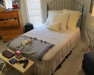 A cute full-size wrought iron bed with a mattress set.  