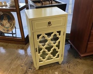 Light Green Side Table / Cabinet with Glass Front Door behind Lattice 