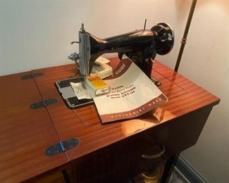 Singer sewing machine in cabinet.