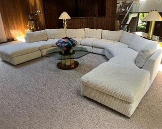 Very large off white vintage sectional that has been well cared for and recovered (additional fabric included). This can be used as shown in your large gathering room or separated to fit your space. There are 4 angled 2-seat sections and 2 ottomans. Seats are 37"D x 23"H. As shown, this measures 13'7" wide x 9'10" deep.