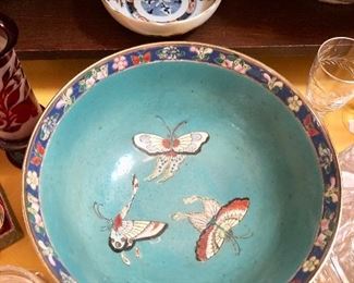 Chinese Qianlong Enameled bowl. Floral, fruit, and butterflies raised to the touch. Artist signed in red on the bottom.