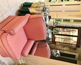 One of two matching salmon upholstered club chairs. 
