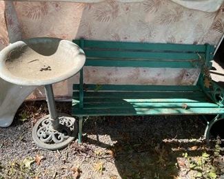 Wooden park bench and plastic birdbath.