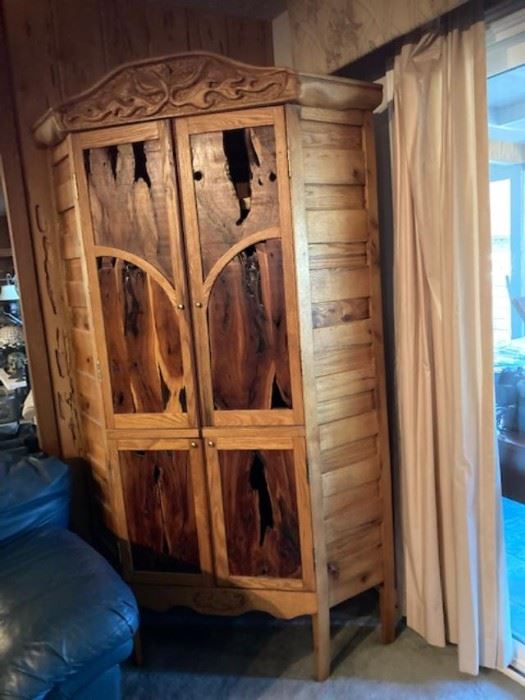 This cabinet was built for Robert and Phyllis Danley of Prescot Valley, Arizona. It was completed April 10th 1994. The redwood used in the doors is manzanita. It came from their previous home in the mountains of Julian, California. The manzanita wood was brought as a stump which was very rotted out and had to be stabilized with resins before being used in the doors. The top area of the doors is mesquite which was found by Robert Danley and the artist in the dry washes of the Hassayampa River near Wickenburg, Arizona. Bob Danlech will not soon forget gathering the wood, since he injured his shoulder in the search, cutting and hauling. The oak wood for the upright corners of the cabinet came from spacers to keep the large pipe seprated for fork, lift operations during the widening of Country Club drive in Mesa, Arizona during October of 1993. The remaining oak slates which form the sides, came from pallets used in shipping printing papers. The thin plywoood shelving, were commercially pu