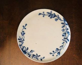 Round blue and white pottery plate with raised motifs