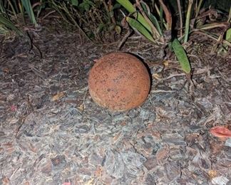 Two cannonballs one larger than the other. One is probably I'm guessing 12 to 14 inches in diameter.