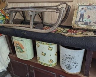Antique sled or sleigh.  Tin toleware waste paper bins. Needlepoint covered 19th century bench. Sitting on a great little cabinet. And milner's form.