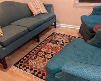 Mid-century chairs underneath the blue upholstery Great great legs for this low profile couch. Nice tribal rug.