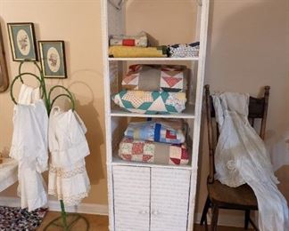 Antique and vintage quilts and antique and vintage children's clothes. They wrought iron stand is not for sale