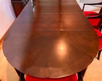 Gorgeous Mid-Century Modern Dining Table with 4 Chairs. This table has 3 Leaves with 4 Red Velvet Seat Cane Back Armed Chairs.