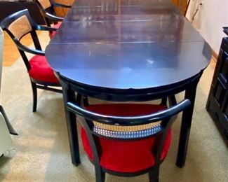 Gorgeous Mid-Century Modern Dining Table with 4 Chairs. This table has 3 Leaves with 4 Red Velvet Seat Cane Back Armed Chairs.