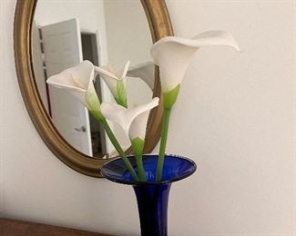 Faux flowers in vase by mirror