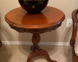 Cute round table, and black and gold bowl with pinecones.